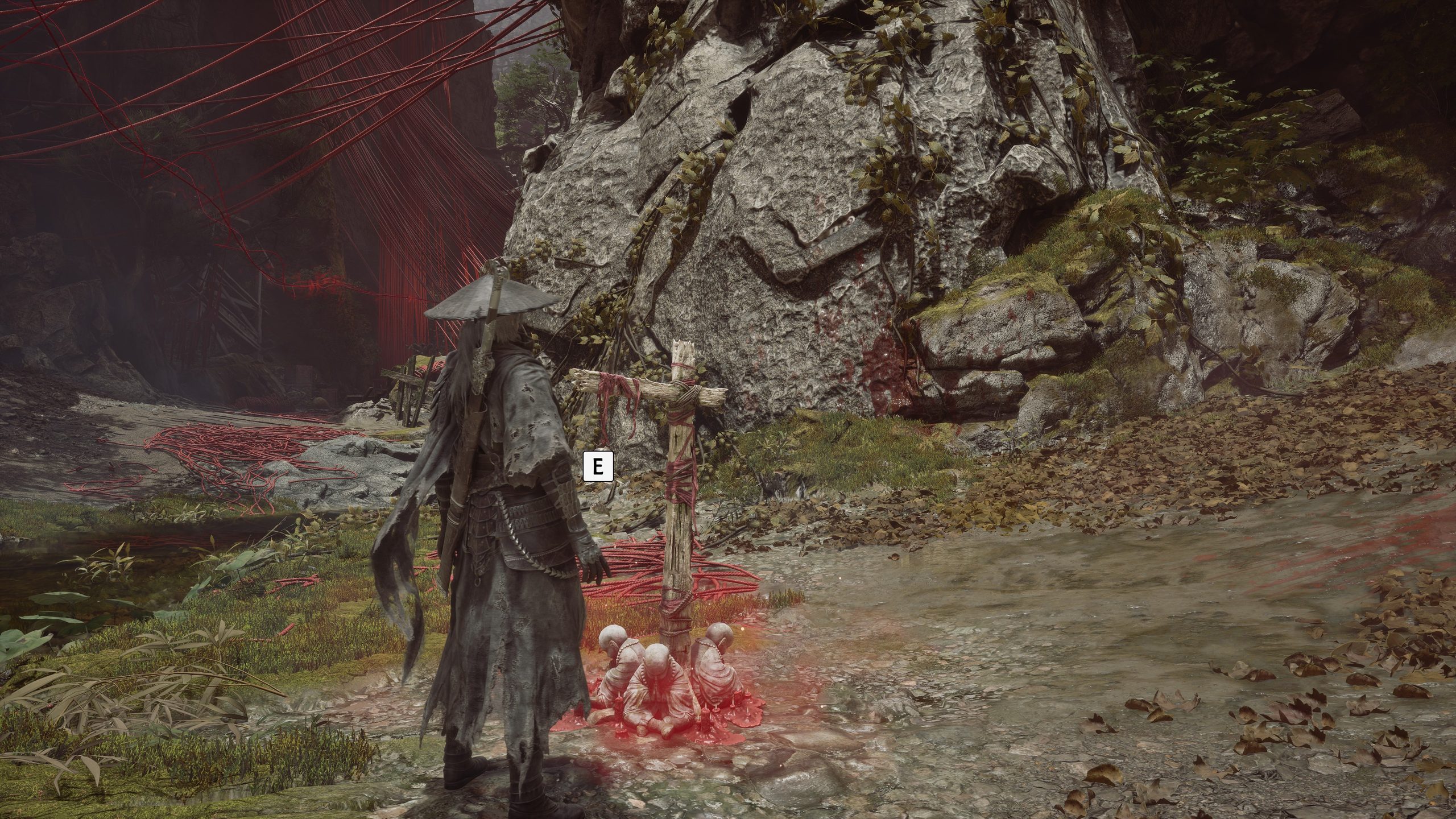 A character dressed in a dark, tattered cloak stands on a forest path in the game Black Myth: Wukong with an 
