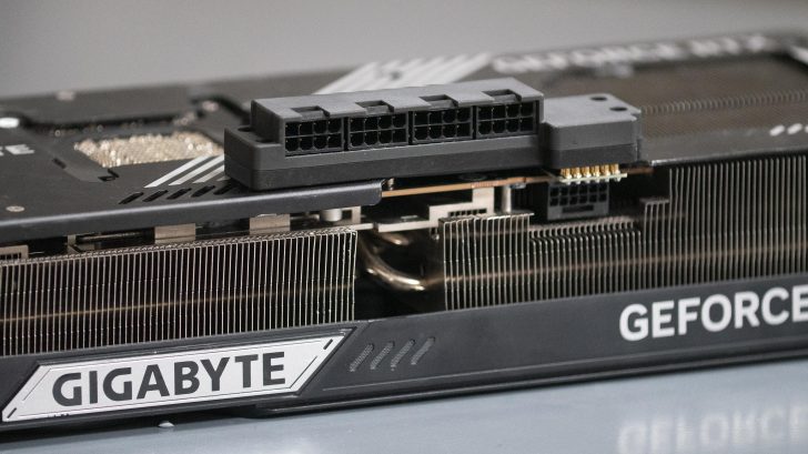 A Gigabyte graphics card with visible 'GIGABYTE' and 'GEFORCE' branding has an exposed power connector and cooling fins.