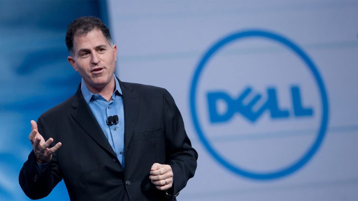 A person speaking on stage with a large Dell logo in the background.