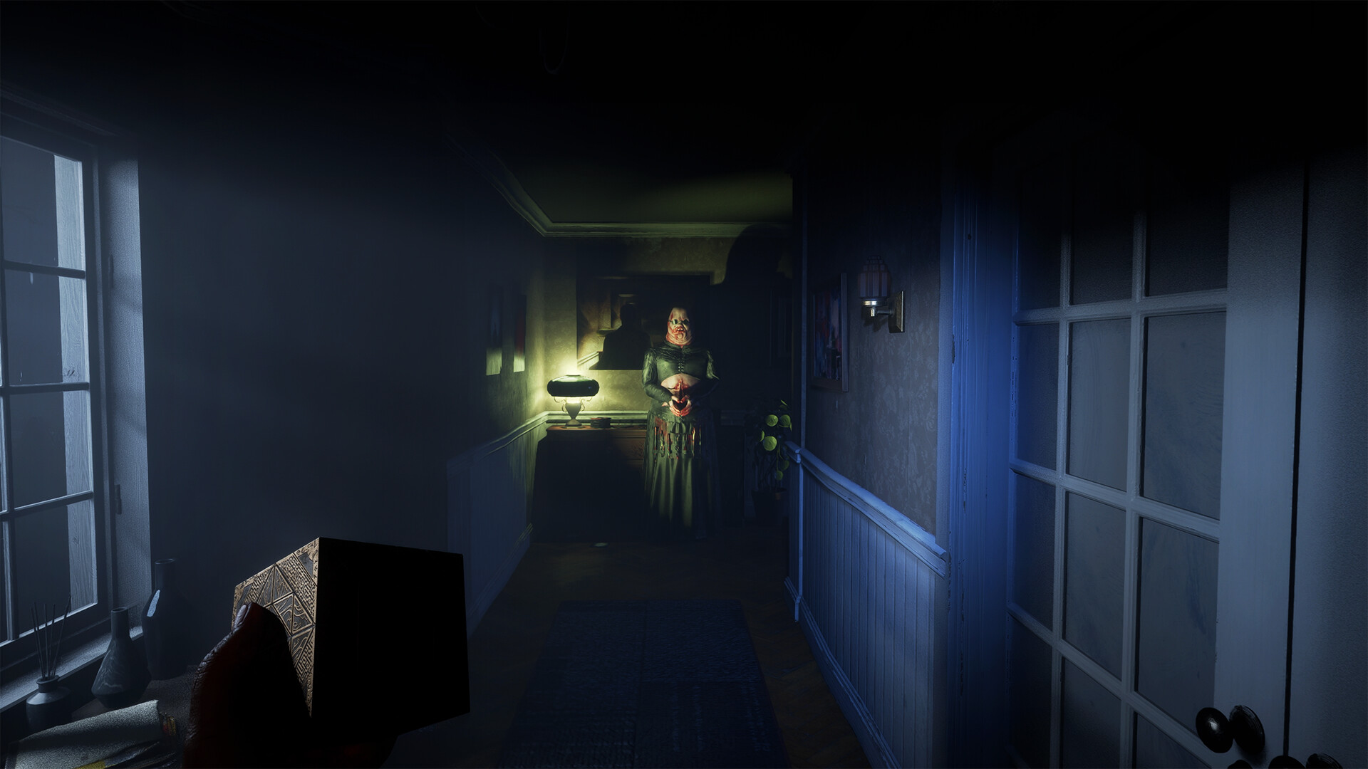 A character holding a detailed cube in a dimly lit hallway faces a figure illuminated by a yellowish lamp in a horror game setting.