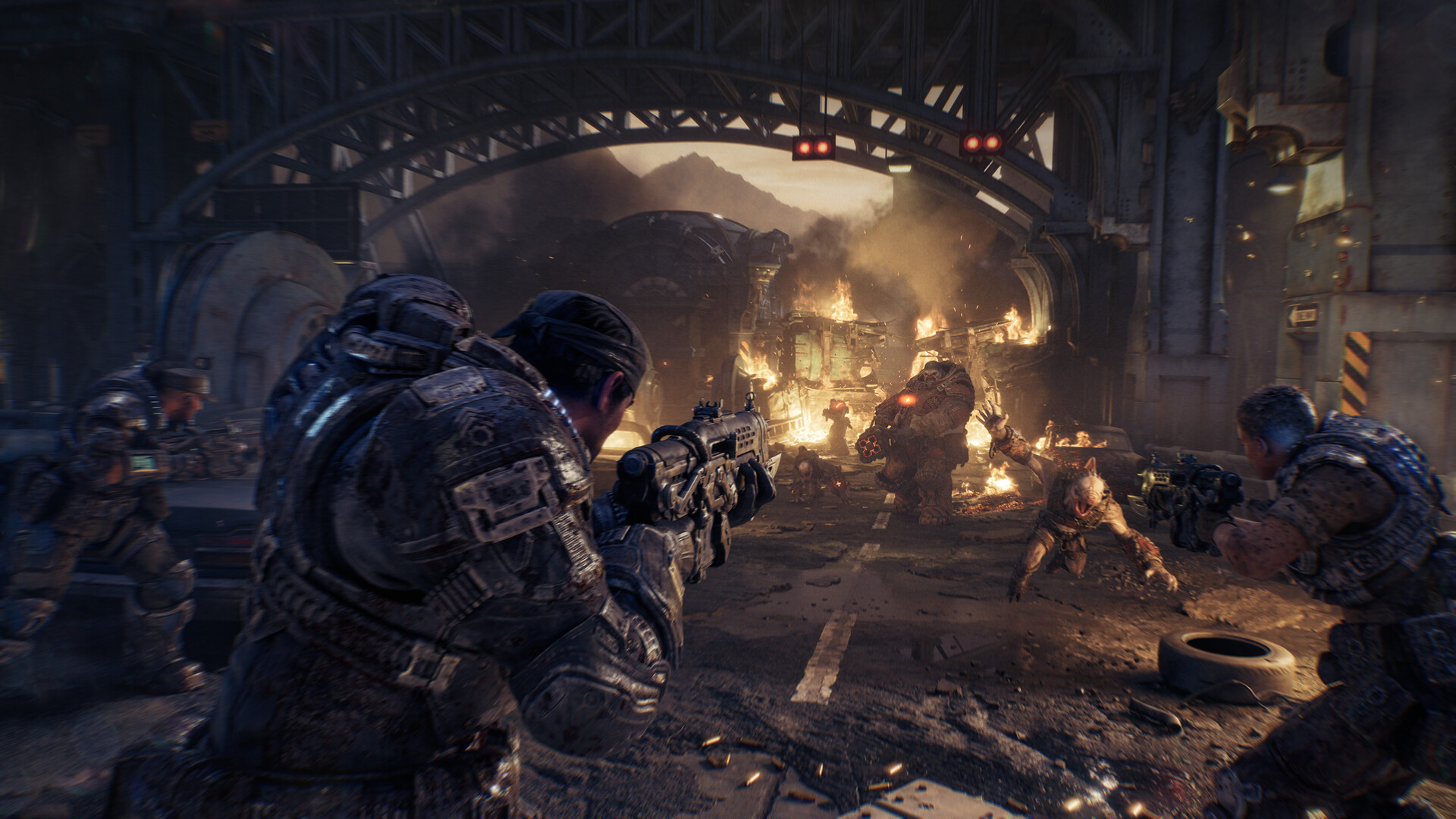 Characters in 'Gears of War' engage in combat with creatures in a burning urban setting.